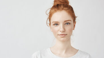Portrait of beautiful redhead girl smiling looking at camera.