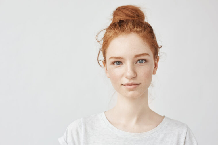 Portrait of beautiful redhead girl smiling looking at camera.