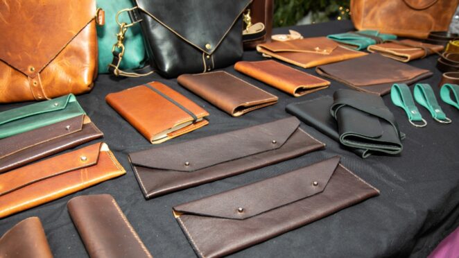 Leather goods arranged on a table with bags, wallets, and accessories displayed neatly