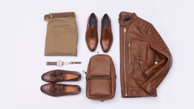 Leather jacket, shoes, belt, and bag laid out neatly on a light surface