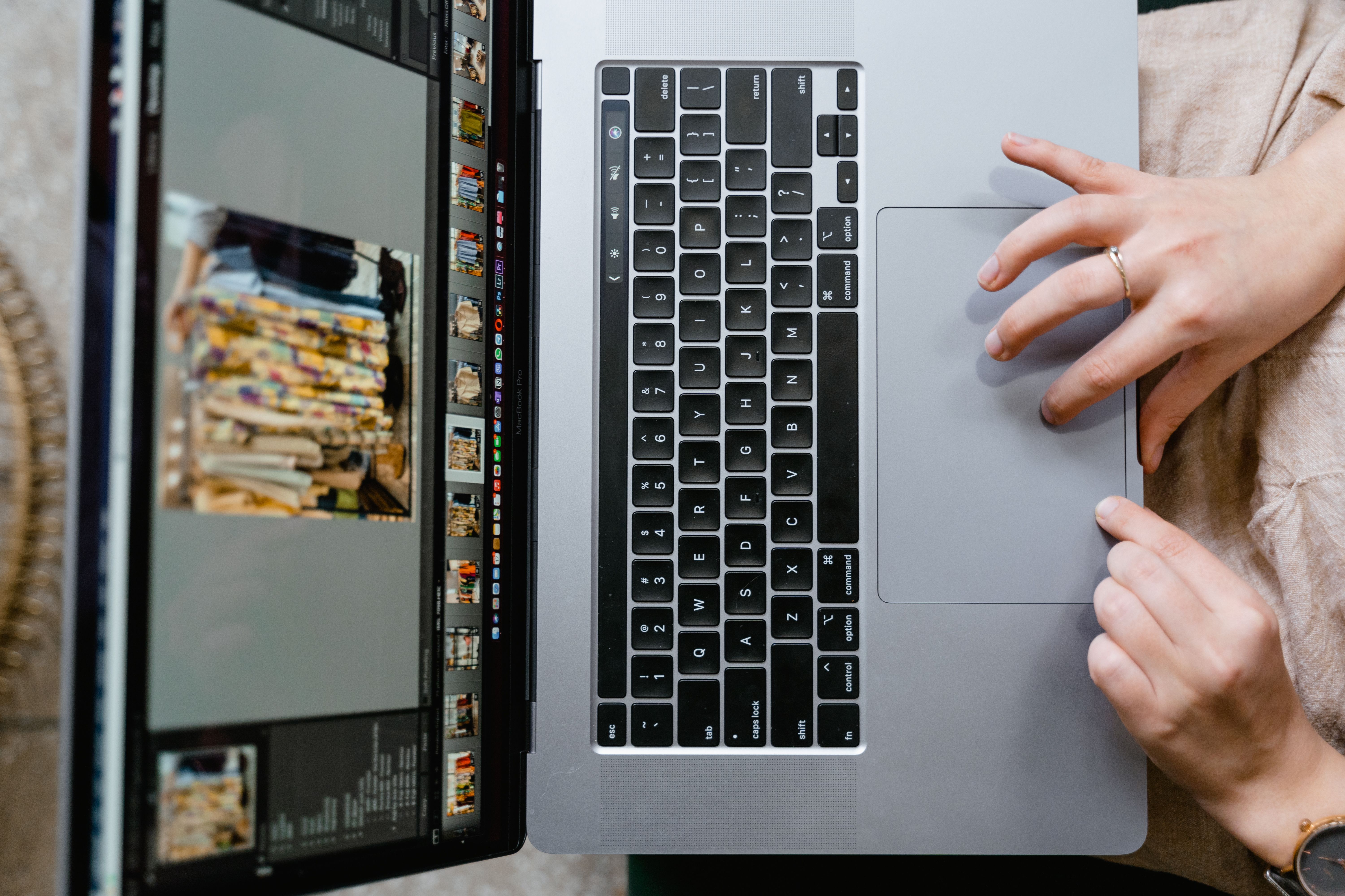Close-up of hands using a laptop for AI photo editing to create social media visuals