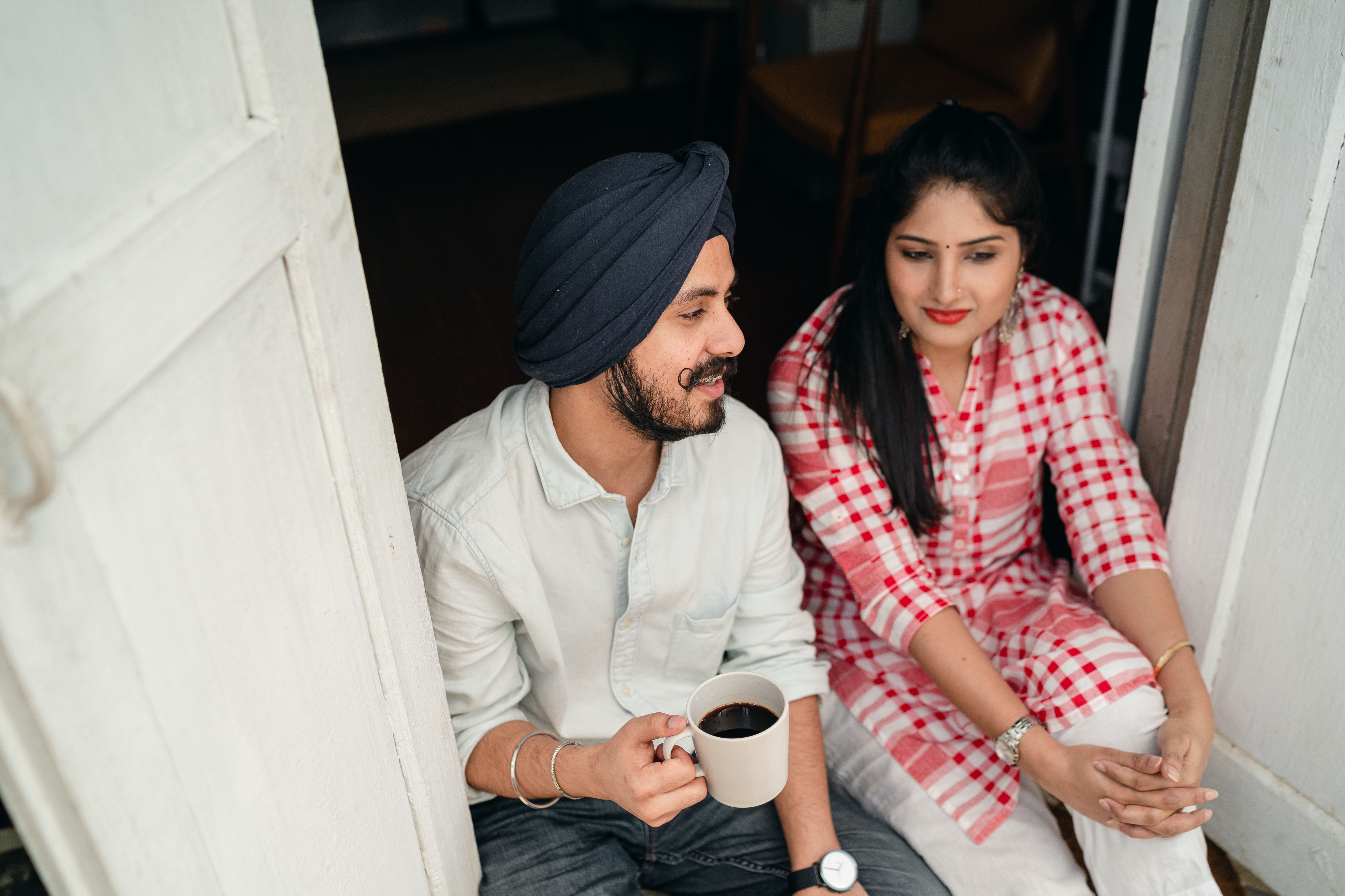 Partner attentively listening while the other shares news over coffee at home