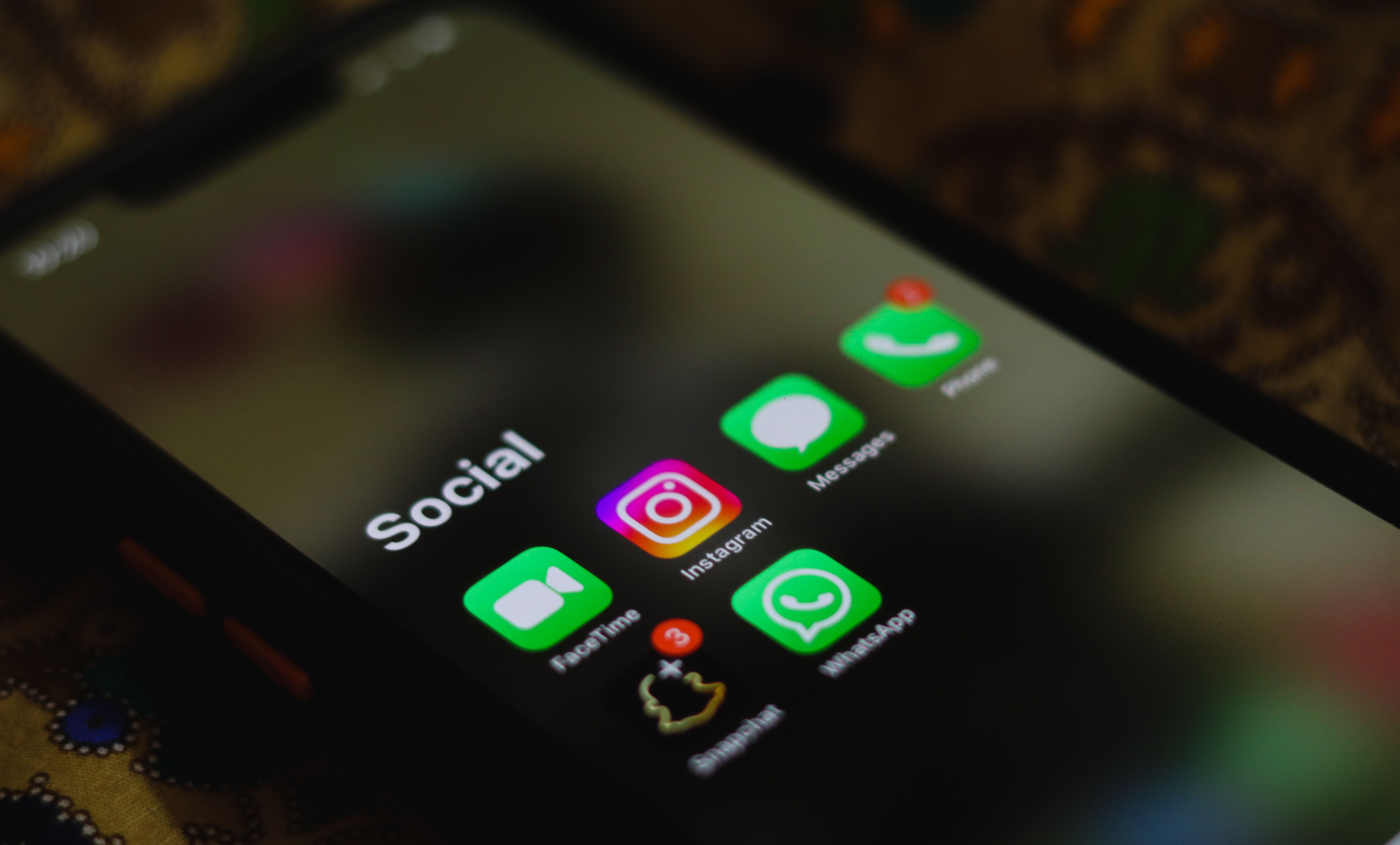 Smartphone screen displaying social media apps for sharing AI-edited content